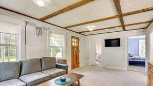 A spacious living room with a sofa, a coffee table, and a wooden ceiling.