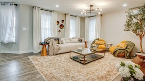 A living room with a sofa, armchair, coffee table, and a potted plant. - Luxe & Cozy Gem: Walk to Beach & Boardwalk - Bikes (Atlantic City)