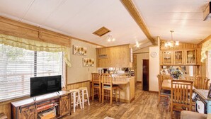 Une cuisine spacieuse dotée de meubles en bois, d’un îlot central et d’un coin repas avec des chaises.