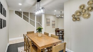 A dining area with a wooden table and chairs, a chandelier, and wall decor. - Outdoor Entertainment Area: Spacious Midland Home! (Midland)
