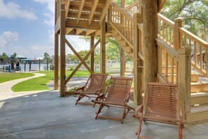 Une terrasse en bois avec deux chaises longues et un escalier.