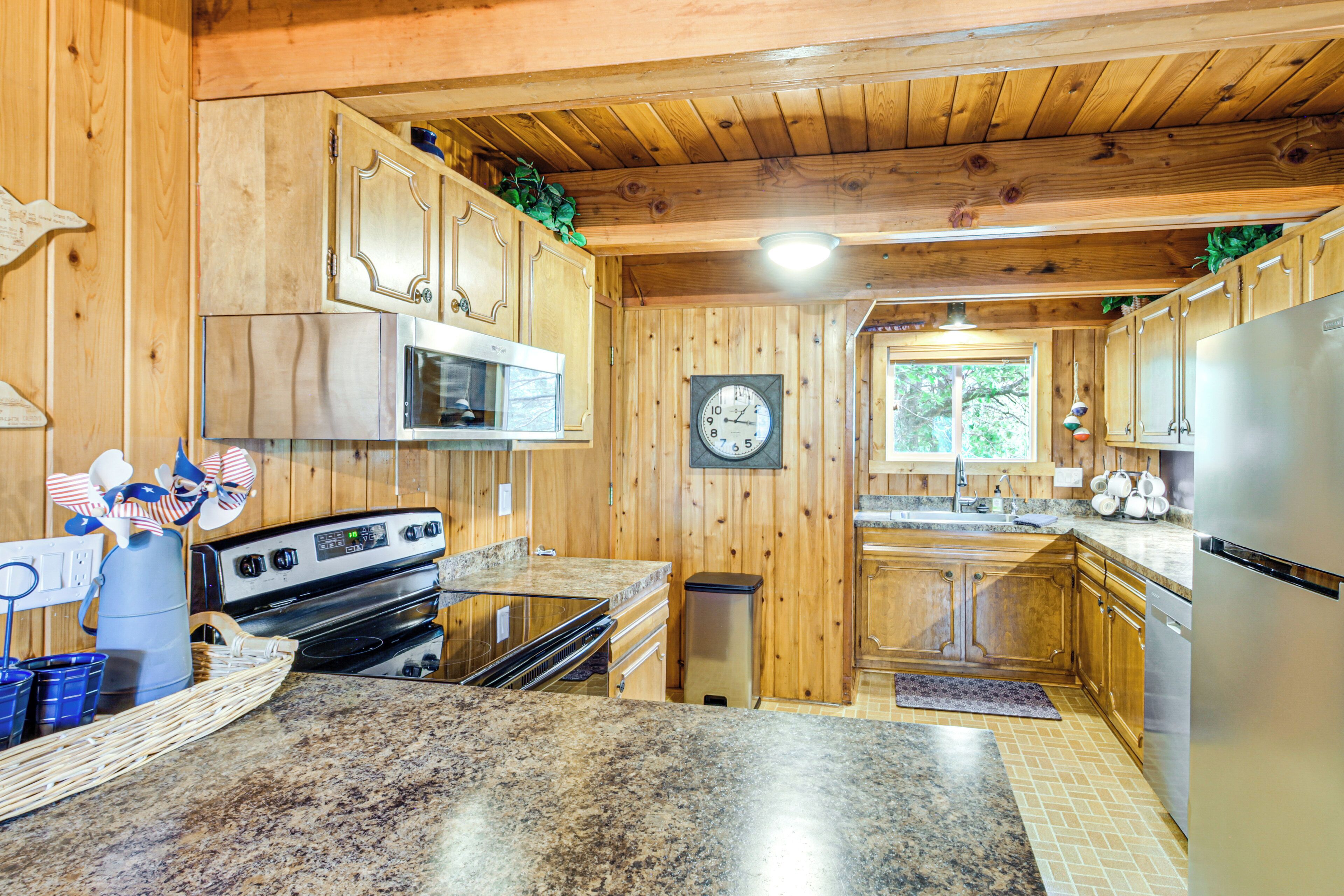 A kitchen with wooden cabinets, stainless steel appliances, and a granite countertop.