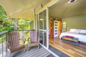 Un dormitorio con una cama, una silla de madera y un banco.