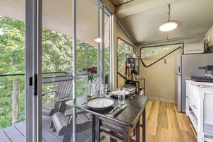 Una cocina con una mesa y sillas dispuestas, un refrigerador y vistas al exterior.