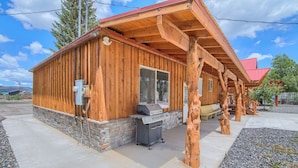 A wooden cabin with a stone foundation, a barbecue grill, and a covered outdoor area. - Group Getaway w/ Mtn Views: Home in Circleville! (Circleville)
