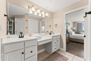 Un baño moderno con lavamanos dobles, un espejo grande y un vestidor.