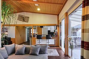 Een moderne woonkamer met een bank, een eethoek en een keuken.