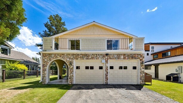 A two-story house with a stone facade, a garage, and a covered driveway. - 2148 Inverness Drive 3 Bedroom Home (South Lake Tahoe)