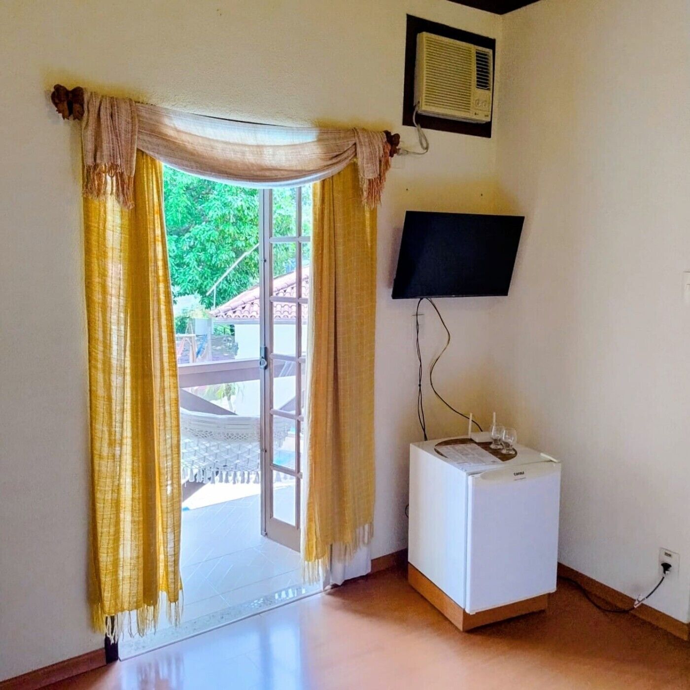 A room with a sliding glass door, a white washing machine, a wall-mounted TV, and a ceiling fan.