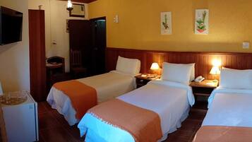 Habitación de hotel con dos camas, televisión, escritorio y una silla.