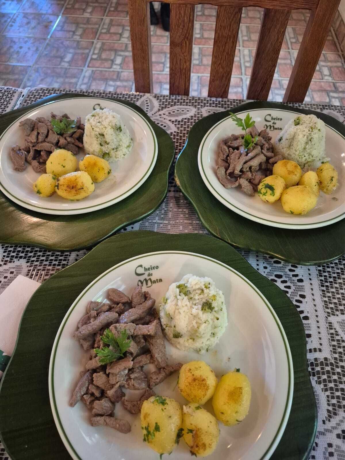 Three plates of food on a table with a patterned tablecloth.