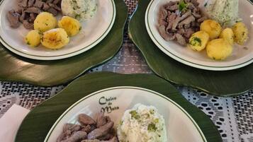Three plates of food on a table with a patterned tablecloth.