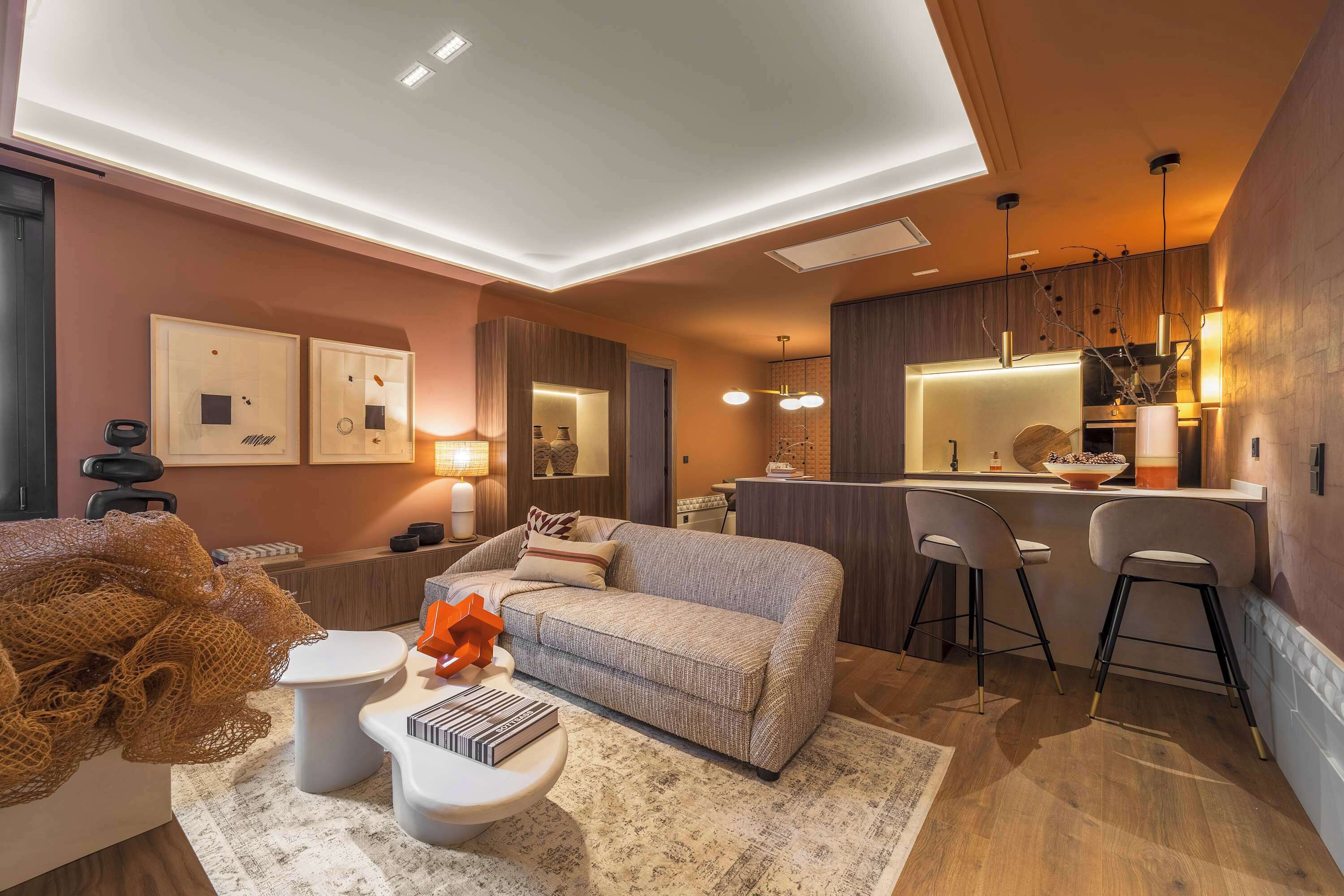 A modern living room with a sofa, coffee table, and bar stools.