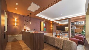 Una sala de estar moderna con un mostrador de recepción de madera, un sofá y una televisión.