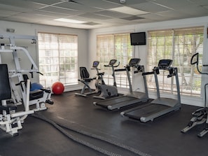 A gym with treadmills, elliptical machines, and a weight bench. - Paradise Island Beach Club (Paradise Island)
