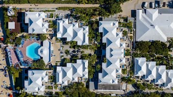 An aerial view of a resort with multiple buildings, a beach, and a pool area.