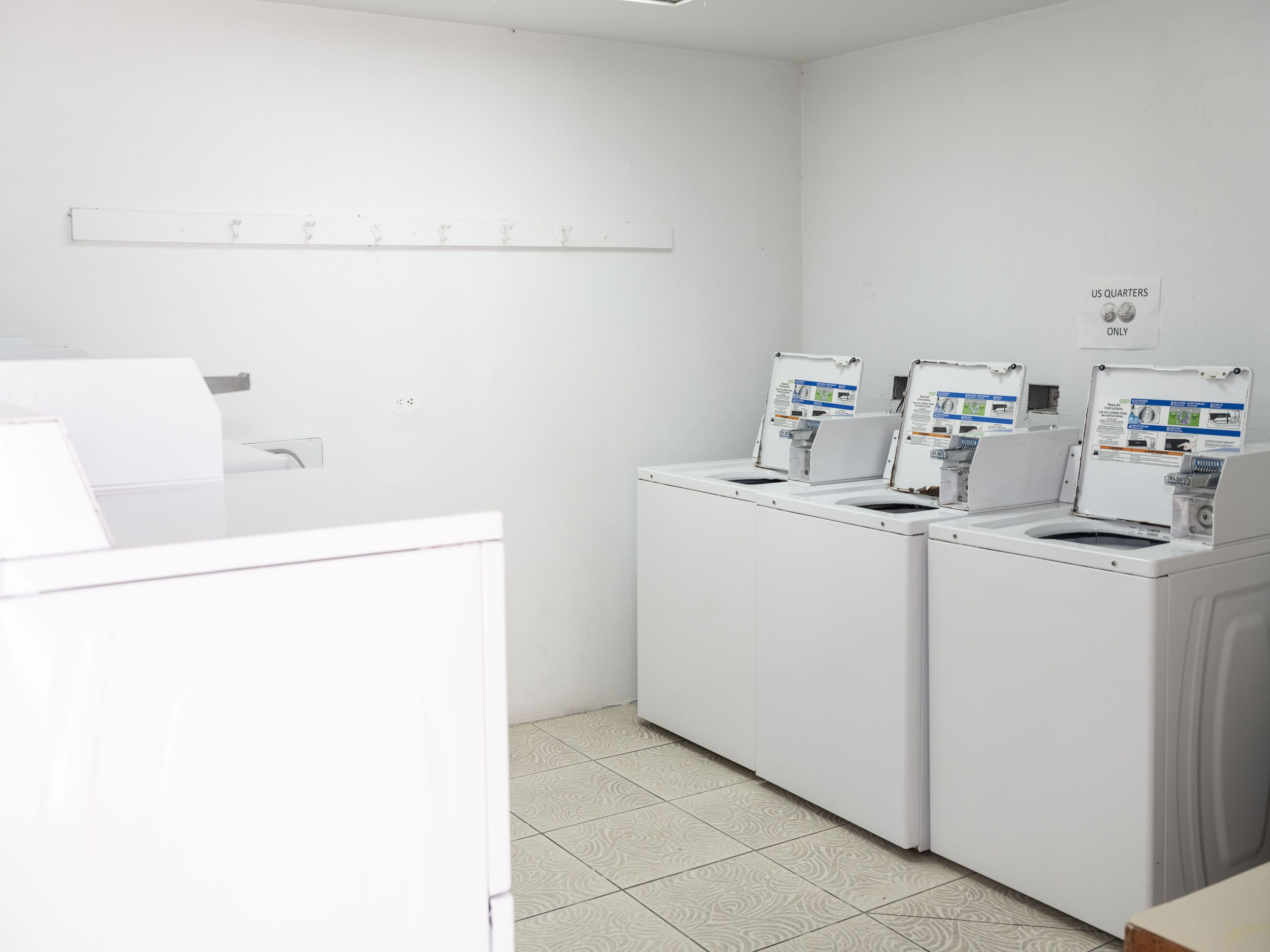 A laundry area with two washing machines and a white counter.