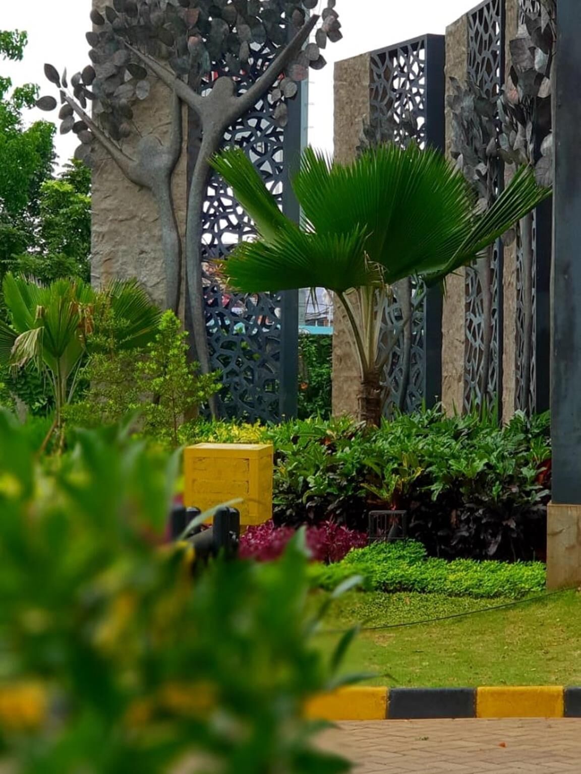 Un jardin aménagé avec une grande variété de plantes et une clôture en métal décorative.