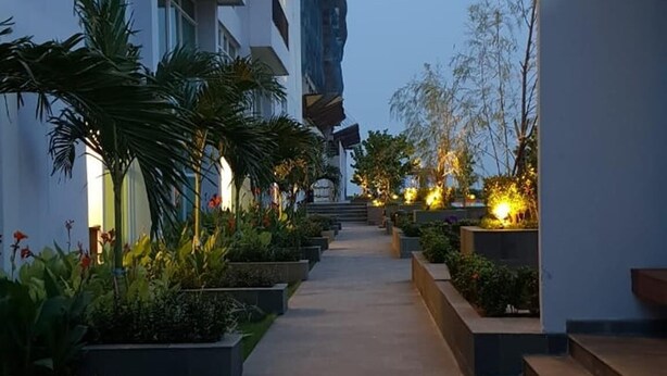Un edificio moderno con un percorso centrale circondato da vegetazione e finestre illuminate.