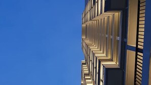 Un edificio moderno con una serie di balconi e finestre.