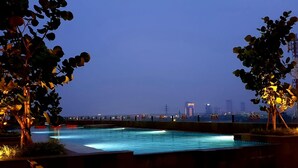 Una piscina con vista sullo skyline della città al crepuscolo.