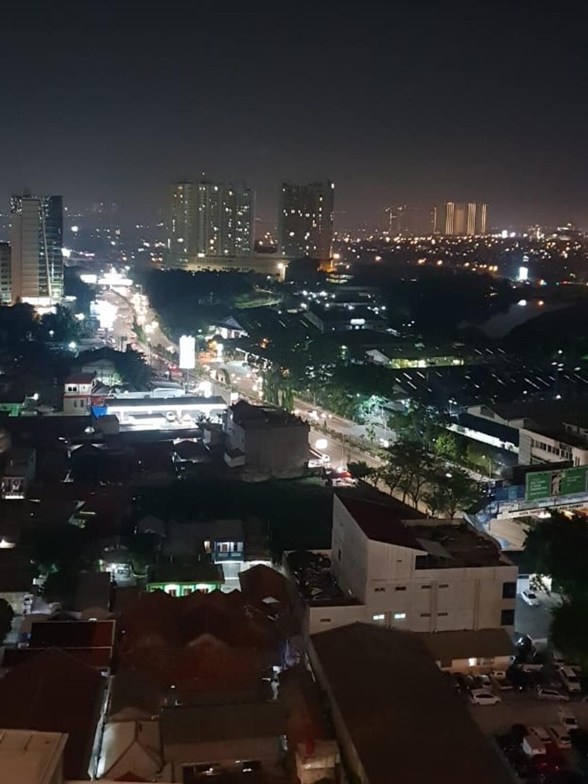 A nighttime cityscape with high-rise buildings and illuminated streets.