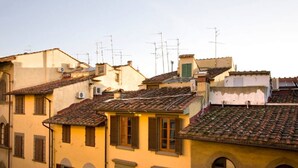 A row of terracotta-roofed buildings with arched windows and shutters. - White Lion - Harmonious apartment near Santa Maria Novella (Florence)