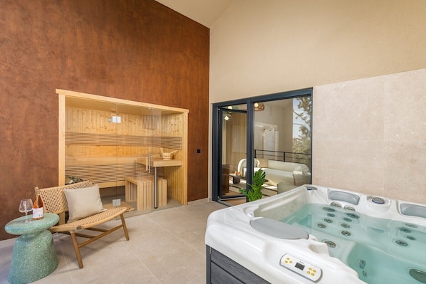 Ein moderner Wellnessbereich mit Whirlpool, Holzmöbeln und einem gläsernen Ruhebereich.