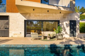 A modern house with a swimming pool, outdoor seating, and a garage. - Villa Mol - A stunnung contemprary villa with large private pool, hot tub and sauna, just a short drive from the sea (Baderna)