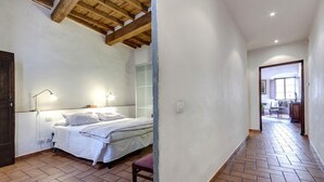 A bedroom with a bed, bedside lamps, and a wooden ceiling. - Niche - View of the Buontalenti Lantern (Florence)