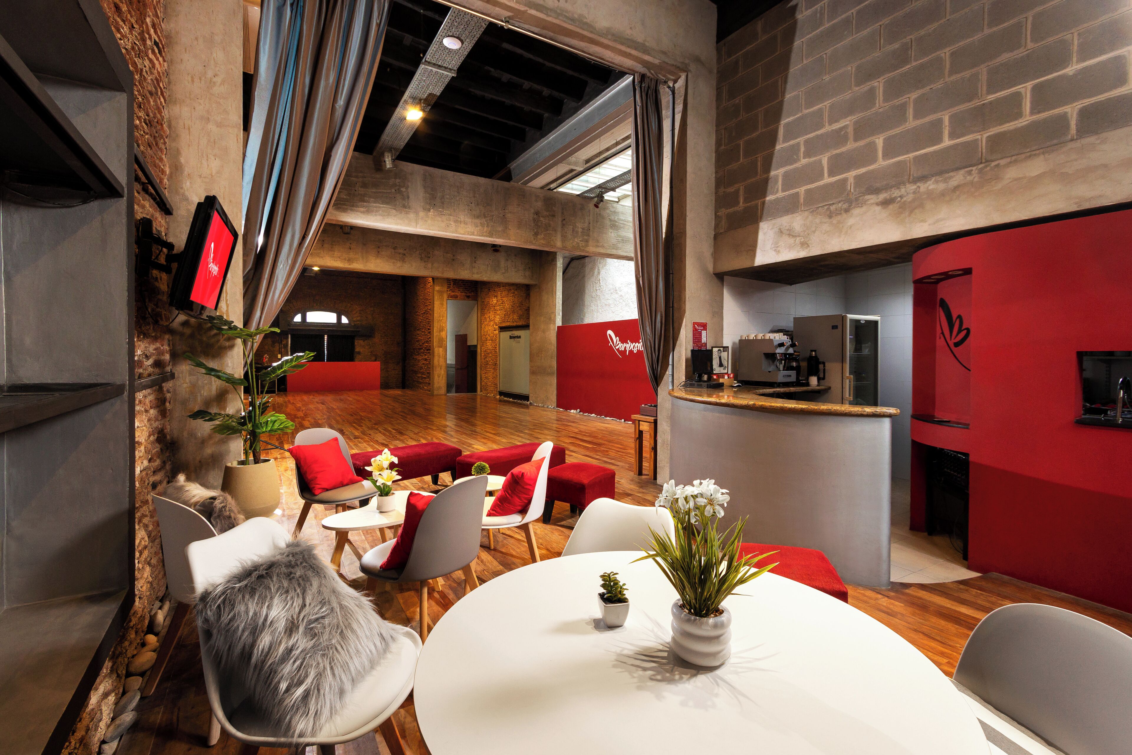 Un interior moderno con comedor, detalles en rojo y una barra de cocina.