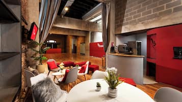 Un interior moderno con comedor, detalles en rojo y una barra de cocina.