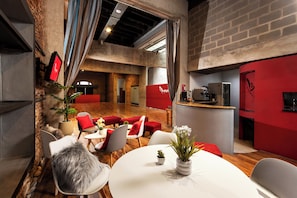 A modern interior with a dining area, red accents, and a kitchen counter. - Mariposita de San Telmo Hotel Boutique (Buenos Aires)