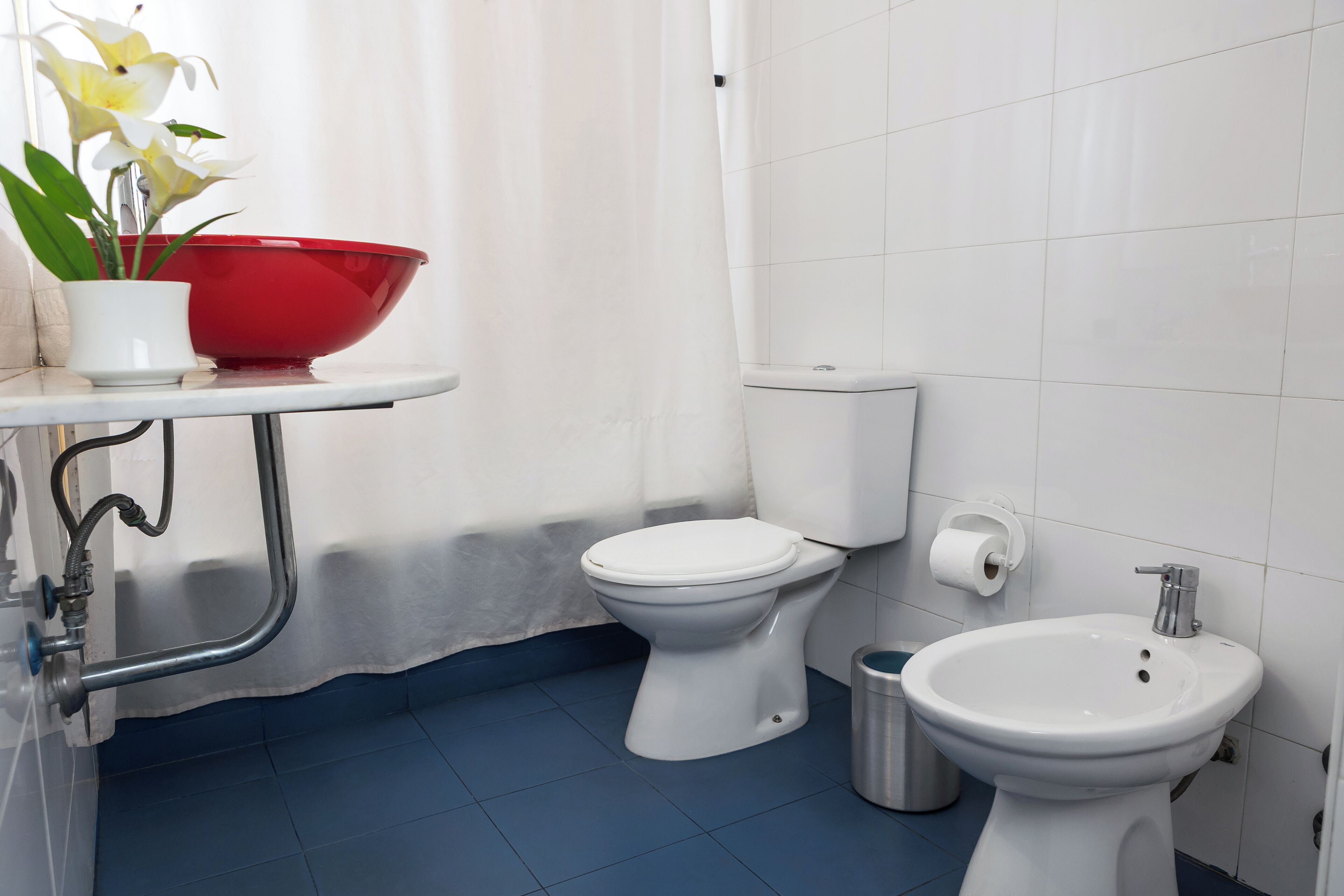 A bathroom with a toilet, bidet, and sink.