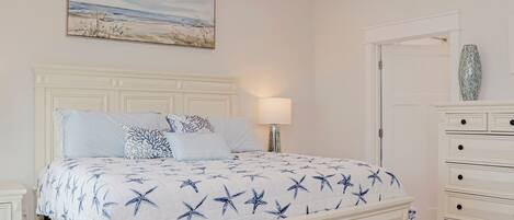 Une chambre à coucher avec un lit, une table de chevet, une commode et un tableau au mur.