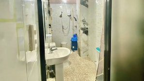 A bathroom with a sink, shower, and tiled floor. - Room-lens Staycation IN Panabo 1bdr BR (Davao)