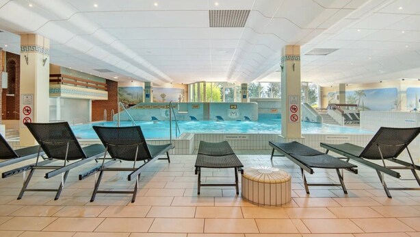 Een zwembadgedeelte met ligbedden en een jacuzzi.