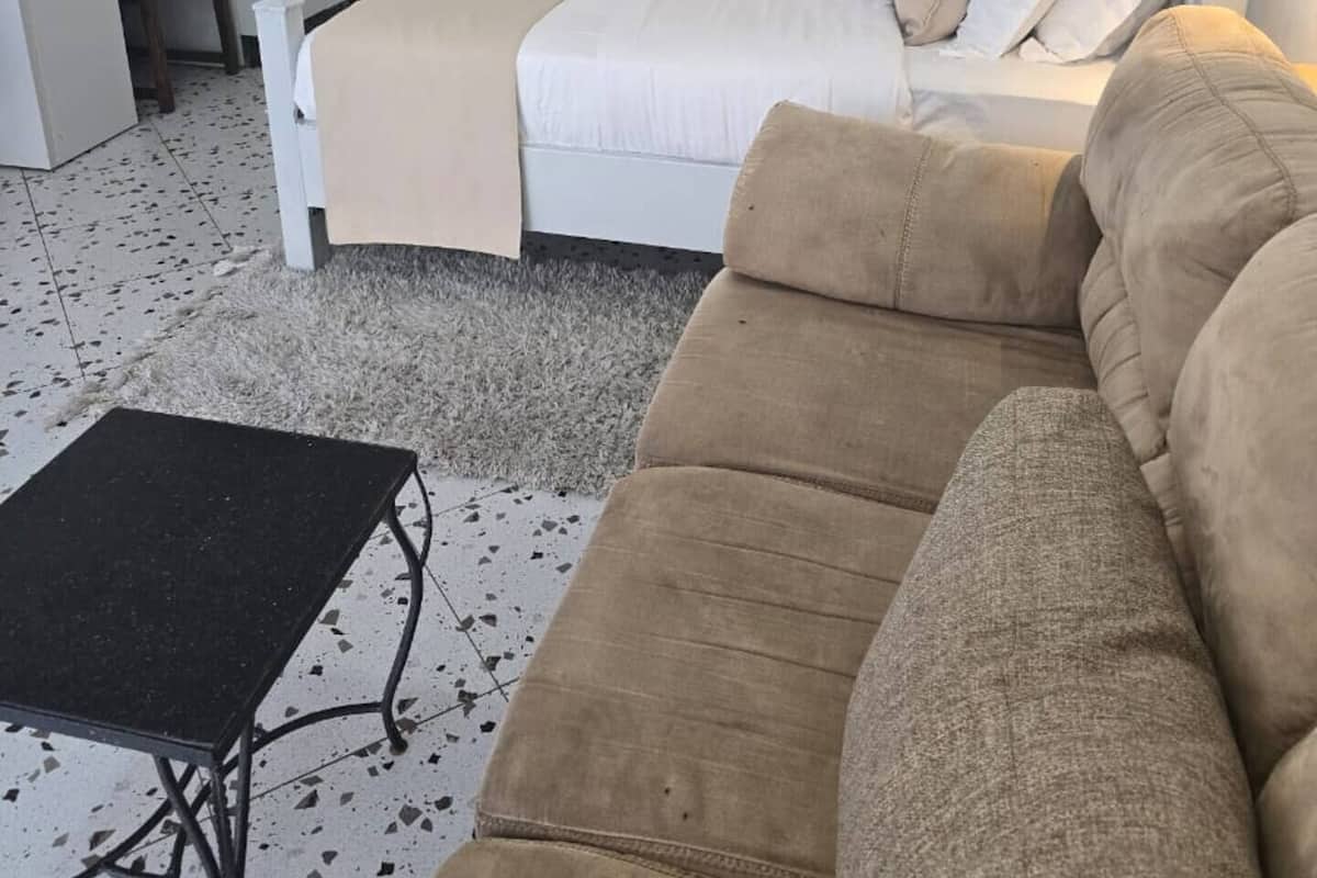 Ein Schlafzimmer mit Bett, Sofa, Schreibtisch und Stuhl.