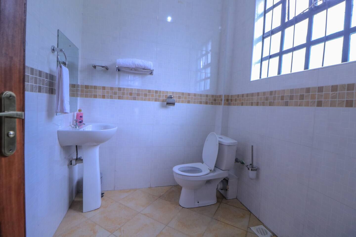 A small bathroom with a toilet, sink, and a mirror.