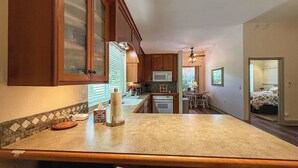A kitchen with wooden cabinets, a central island, and pendant lighting.