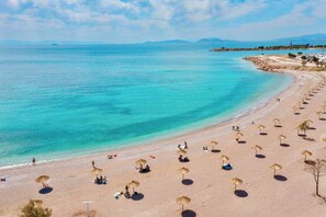 A beach with umbrellas and people. - Beachside Retreat in Glyfada (Glifada)