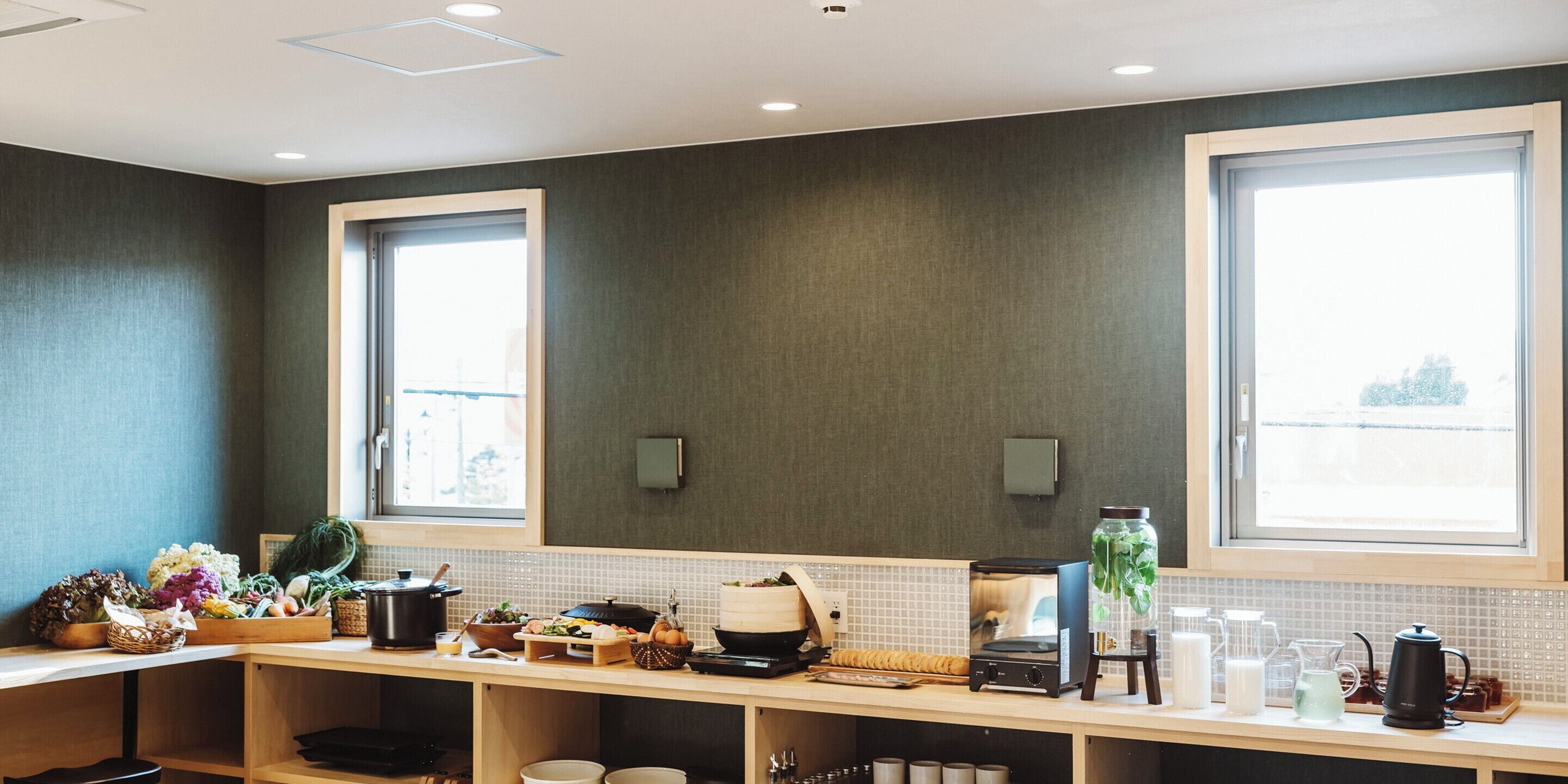 A modern kitchen with a wooden countertop, a stove, and a window.
