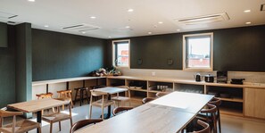 A modern restaurant interior with a long communal table, individual seating, and a kitchen area visible through the counter. - BedandVegetable Kahoku (Kahoku)