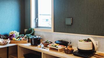 A kitchen with a variety of fresh produce, a slow cooker, and a bread machine on the counter.