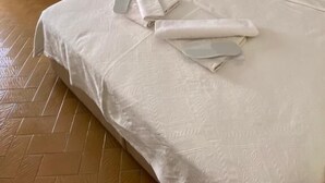 A hotel room with a large bed, a wardrobe, an air conditioning unit, and a nightstand. - Saray Otel (Kas)