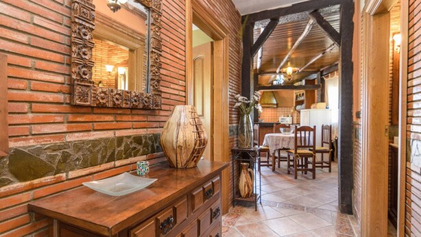 A rustic kitchen with exposed brick walls, wooden beams, and a stone countertop. - Mulhacén Tourist Apartment (Lanjarón)