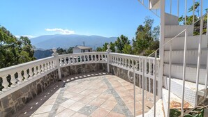 A curved balcony with stone flooring and white balustrades, overlooking a mountainous landscape. - Mulhacén Tourist Apartment (Lanjarón)
