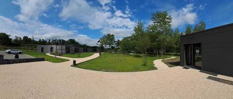 A modern building with a gravel driveway and a pathway leading to a parking area.