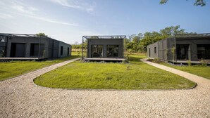 Un edificio moderno con tres unidades, cada una con techo plano y ventanas grandes.