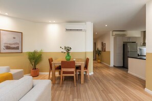 Una sala moderna con una mesa de comedor, sofá y plantas en macetas.